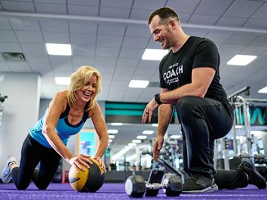 Coach training member at Anytime Fitness.