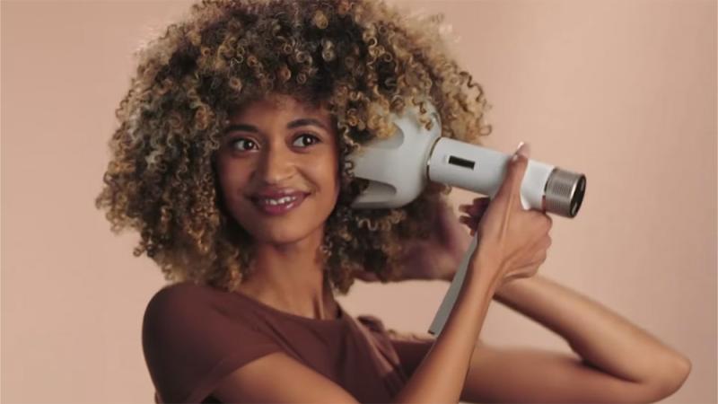 Model with textured hair using Shark Beauty styling tool