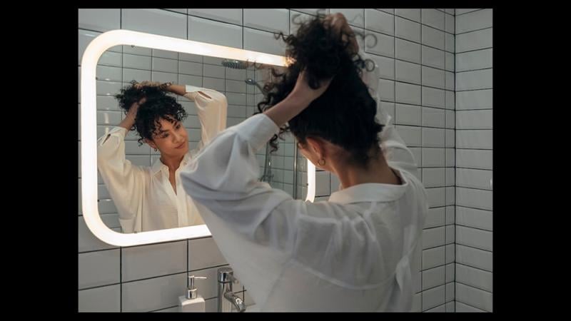 image of woman putting hair up in a bun