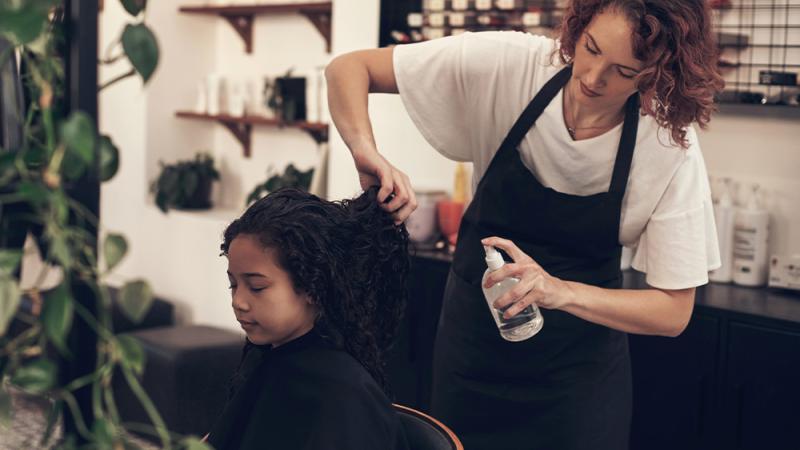 Female stylist and young female client with thick textured hair