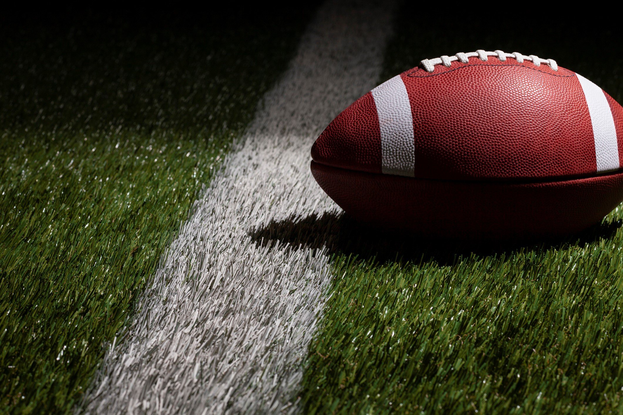 Low angle view of a football at a yard line with dramatic lighting - stock photo WillardGetty Images