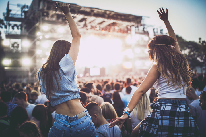 Back view of female friends having fun at a music concert