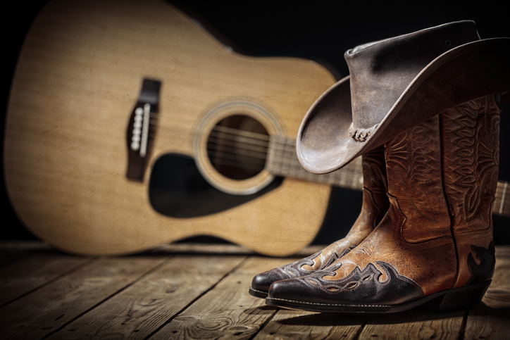 Country music festival live concert with acoustic guitar cowboy hat and boots