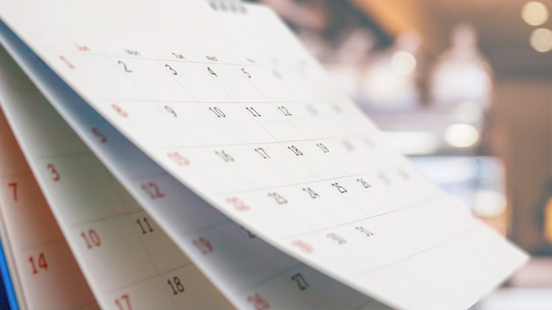 Close up white paper desk calendar with blurred background
