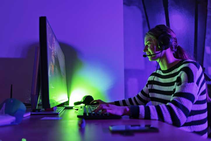 Teenage girl playing multiplayer online games using desktop PC