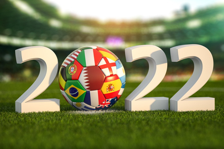 Football world championship 2022 in Qatar Soccer ball with flags of world countries on the grass field of football stadium