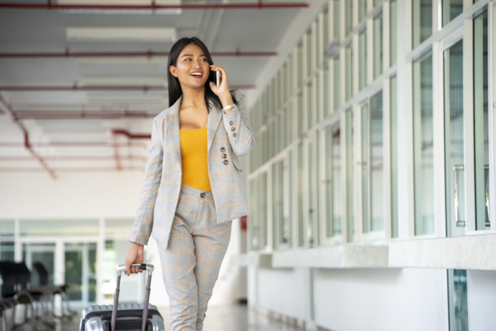 Businesswoman Dragging suitcase luggage bag walking to passenger boarding in Airport Woman travel to work