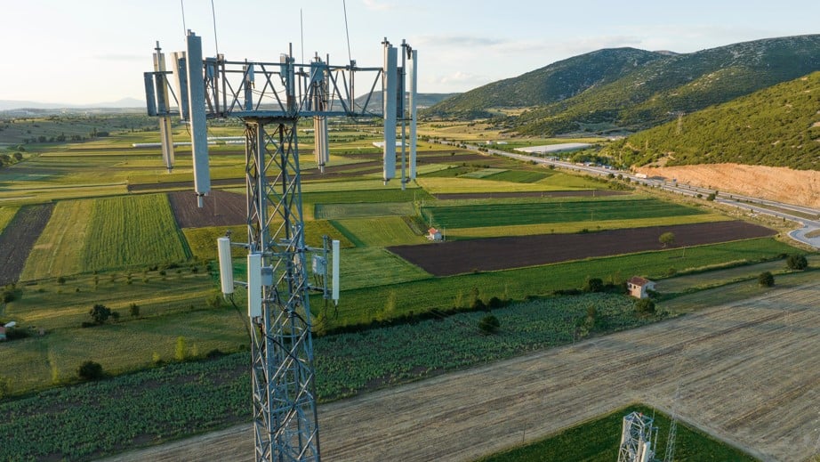 cell tower up close from drone view with green fields in background