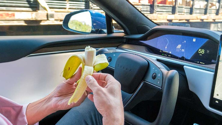 man eats banana at drivers wheel
