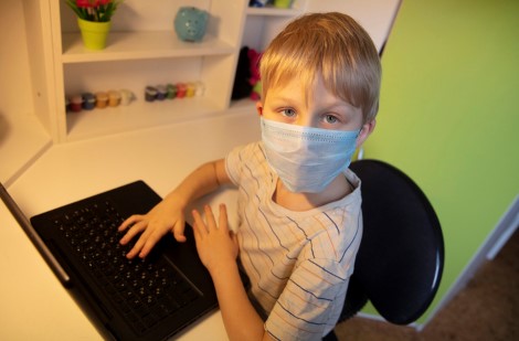 kid with mask on laptop