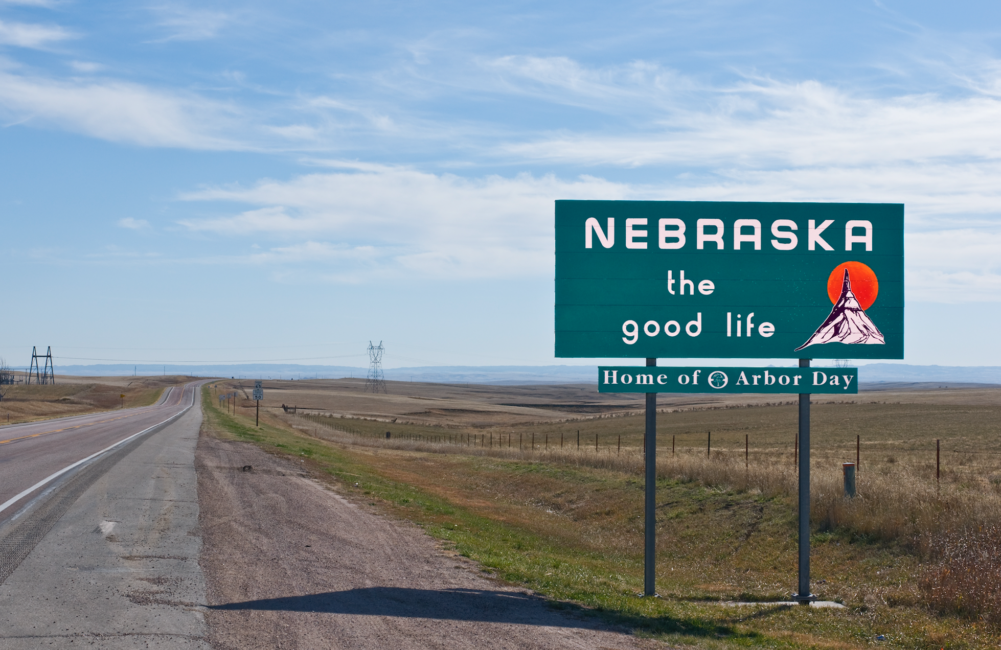 A picture of the Nebraska state sign by the side of a rural road