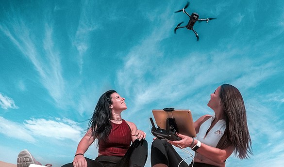 two women watching a drone overhead
