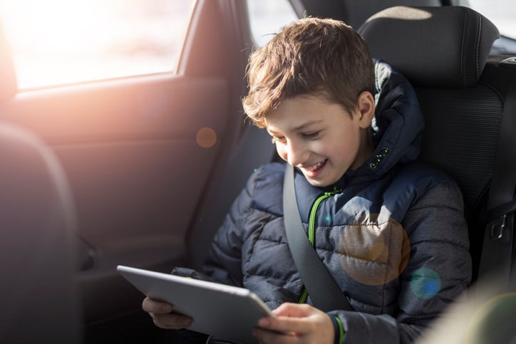 child on tablet in car 