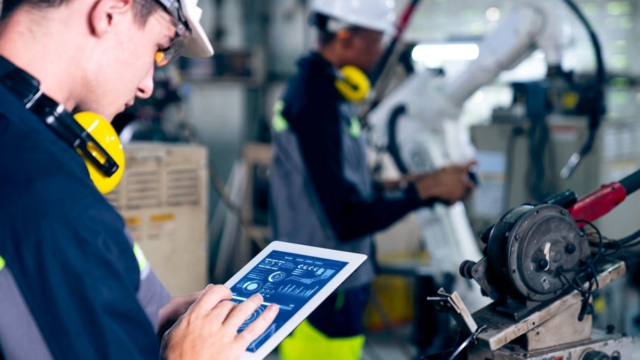 man in hardhat using tablet for controls