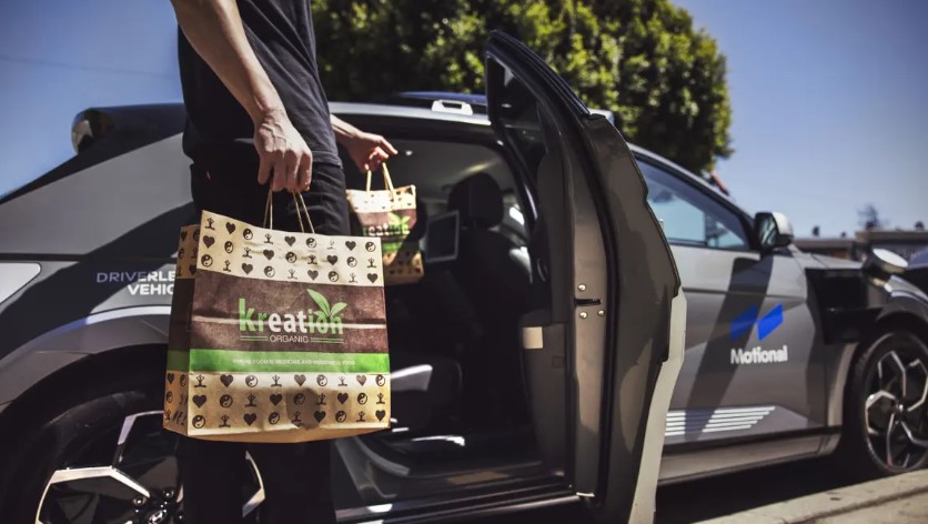 food delivery bag carried by hand into an autonomous vehicle