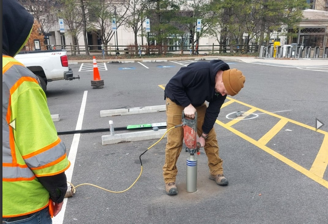 man installs sensors in pavement