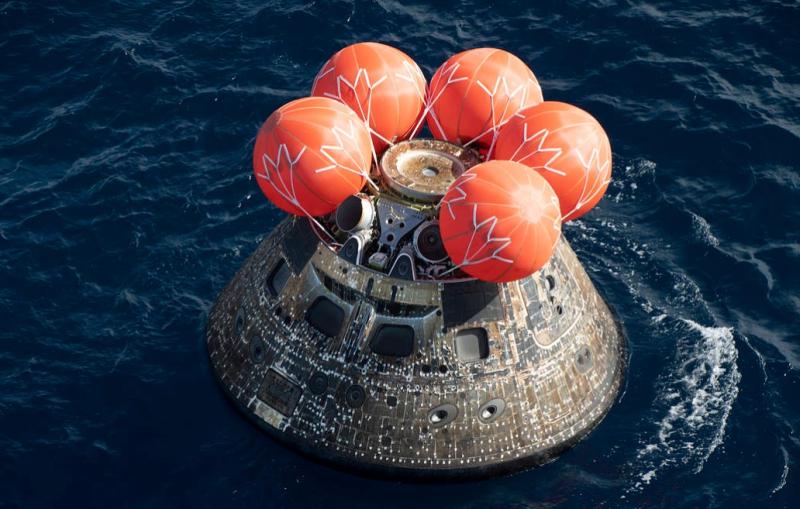 helium filled bags atop Orion crew module in water