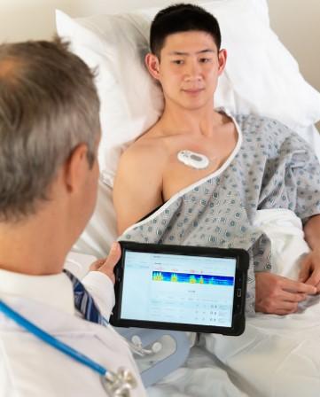 man in bed with medical wearable RESP on chest