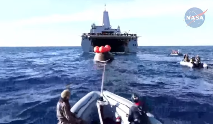 orion on cable being towed into well deck of ship
