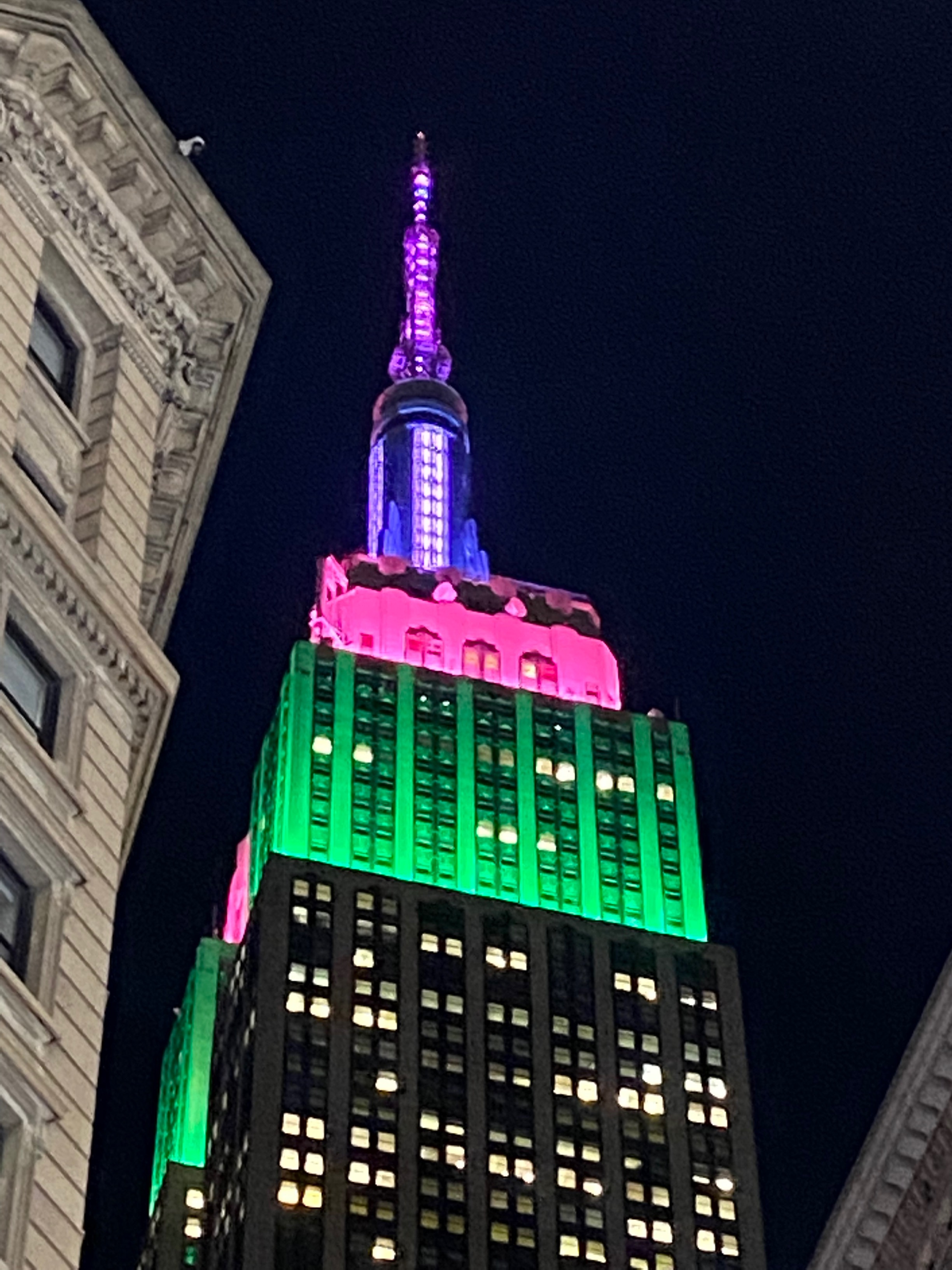 The Empire State Building in pink purple blue and green