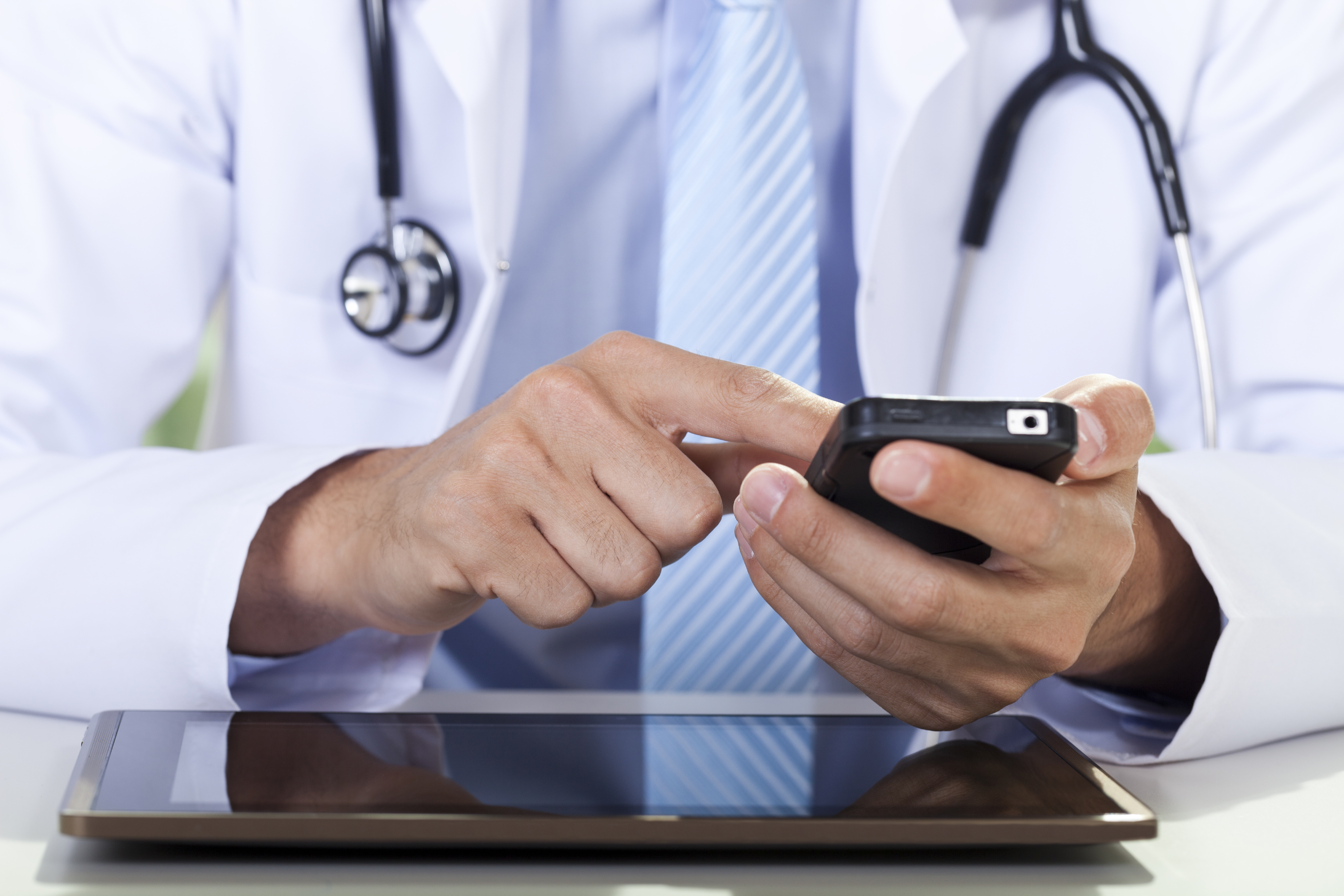 Doctor using cellphone and tablet