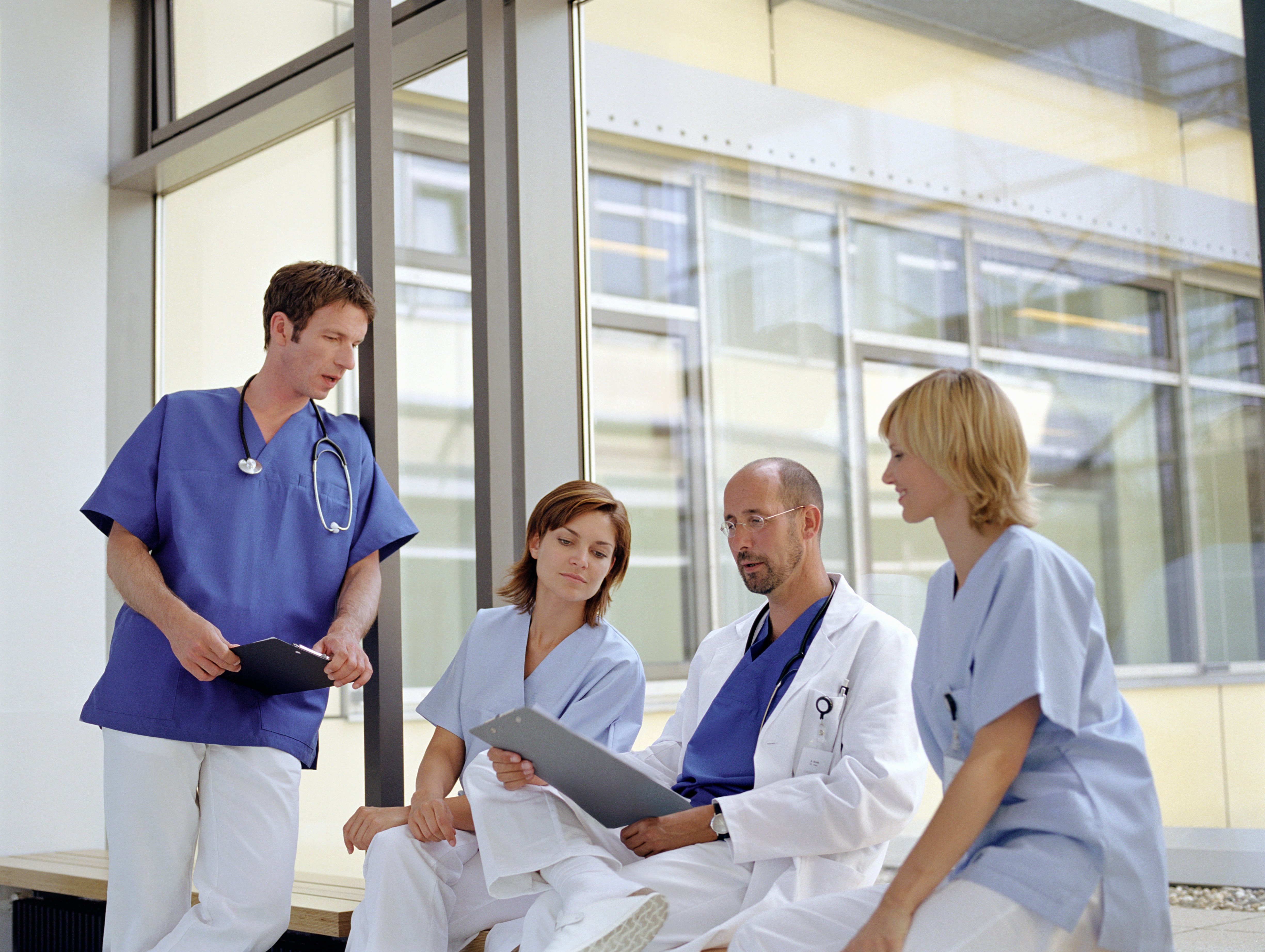 Healthcare workers gathering by a window in a hospital