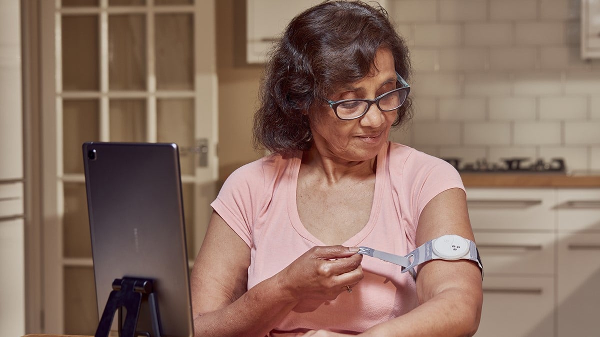 senior woman uses digital blood pressure monitor