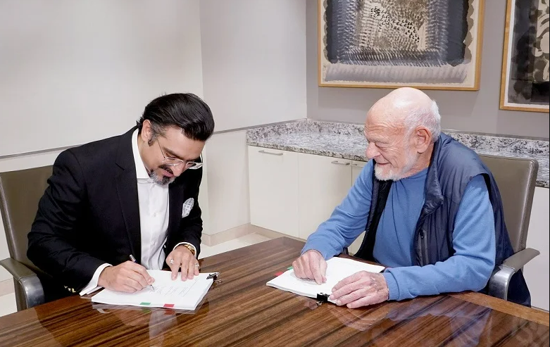 The signing agreement between EGI founder and chairman Sam Zell and Pure Health CEO Farhan Malik