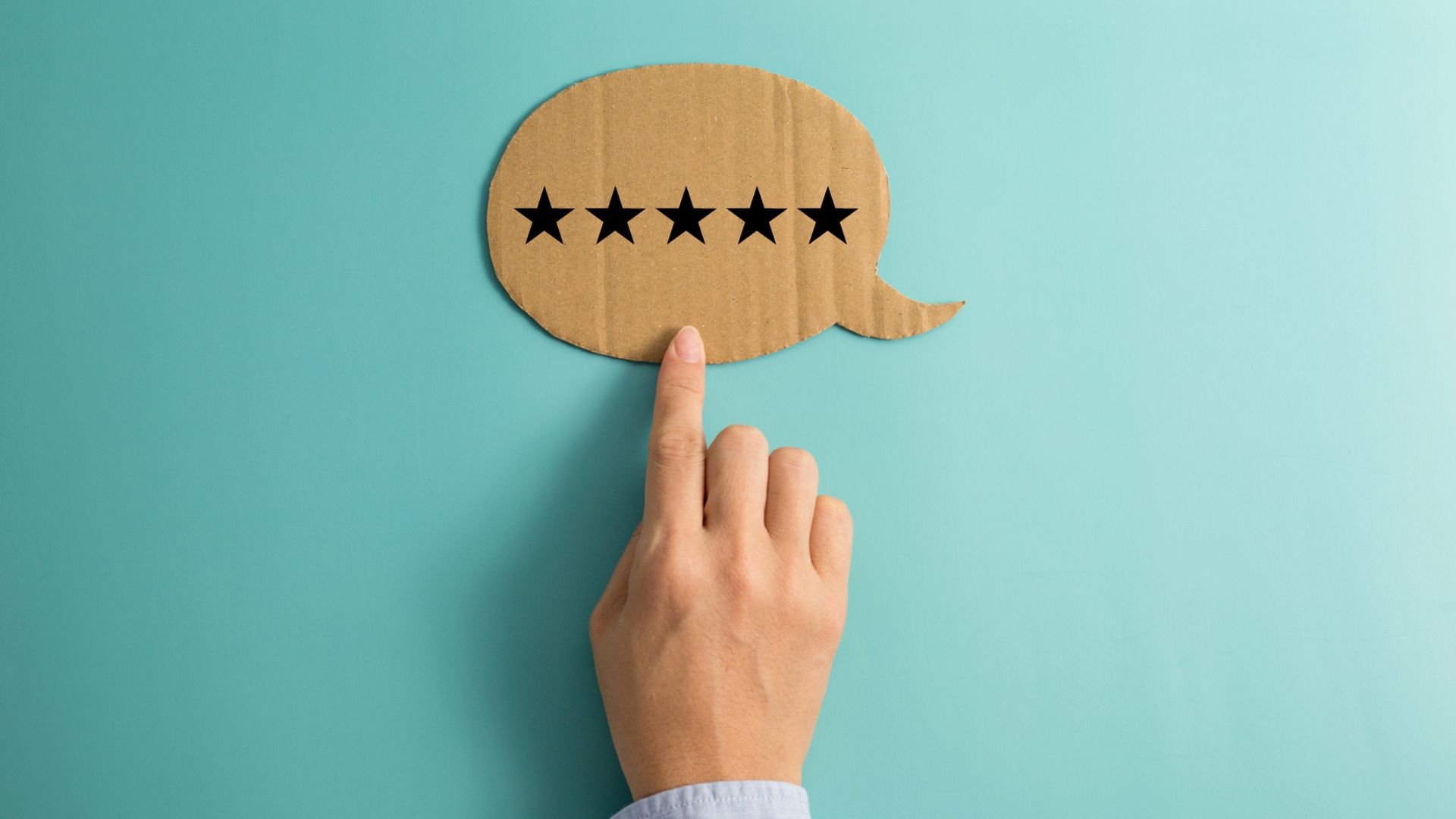 Hand pointing to paper speech bubble with five stars
