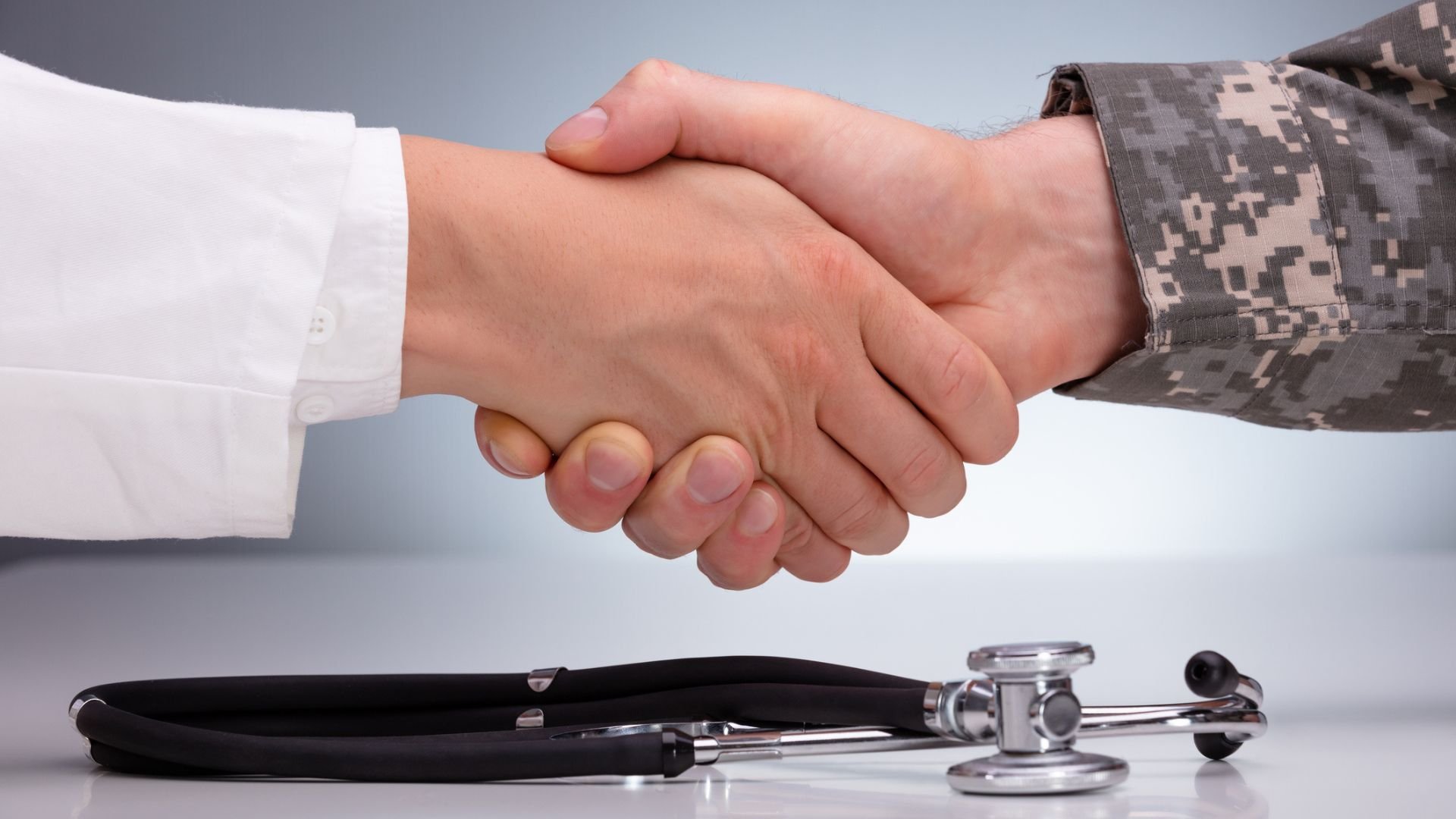 Doctor and military member shake hands