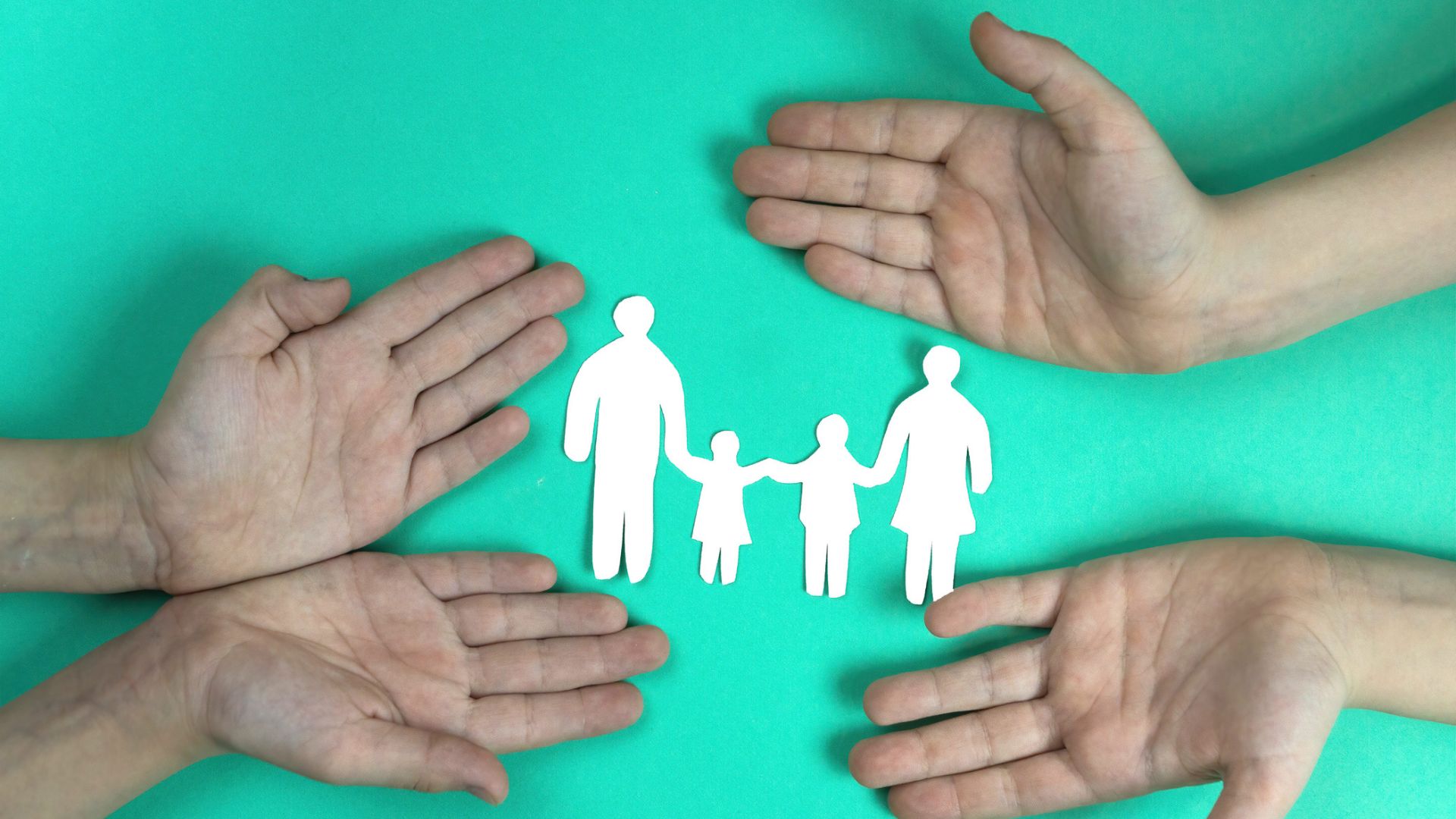 Hands around paper cut-out of family