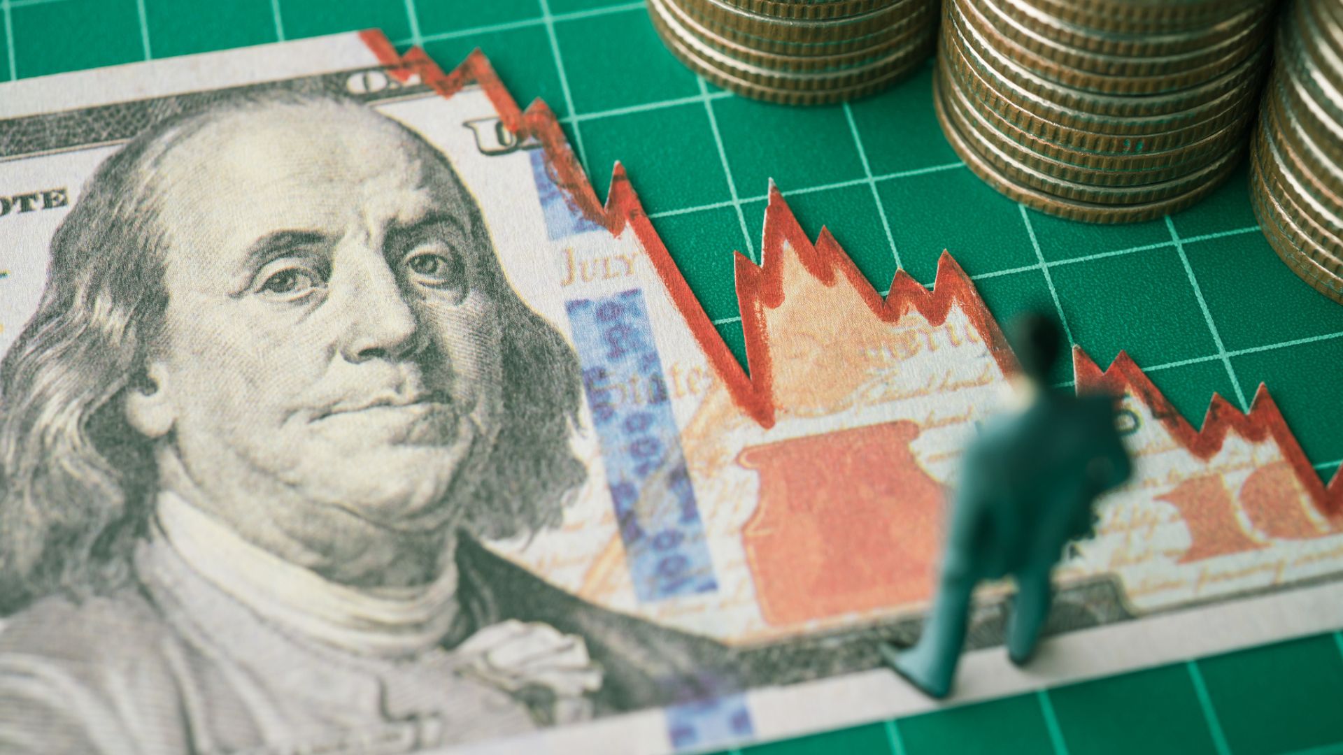 Businessman looking at US dollar banknote tear off as falling down graph tensely 