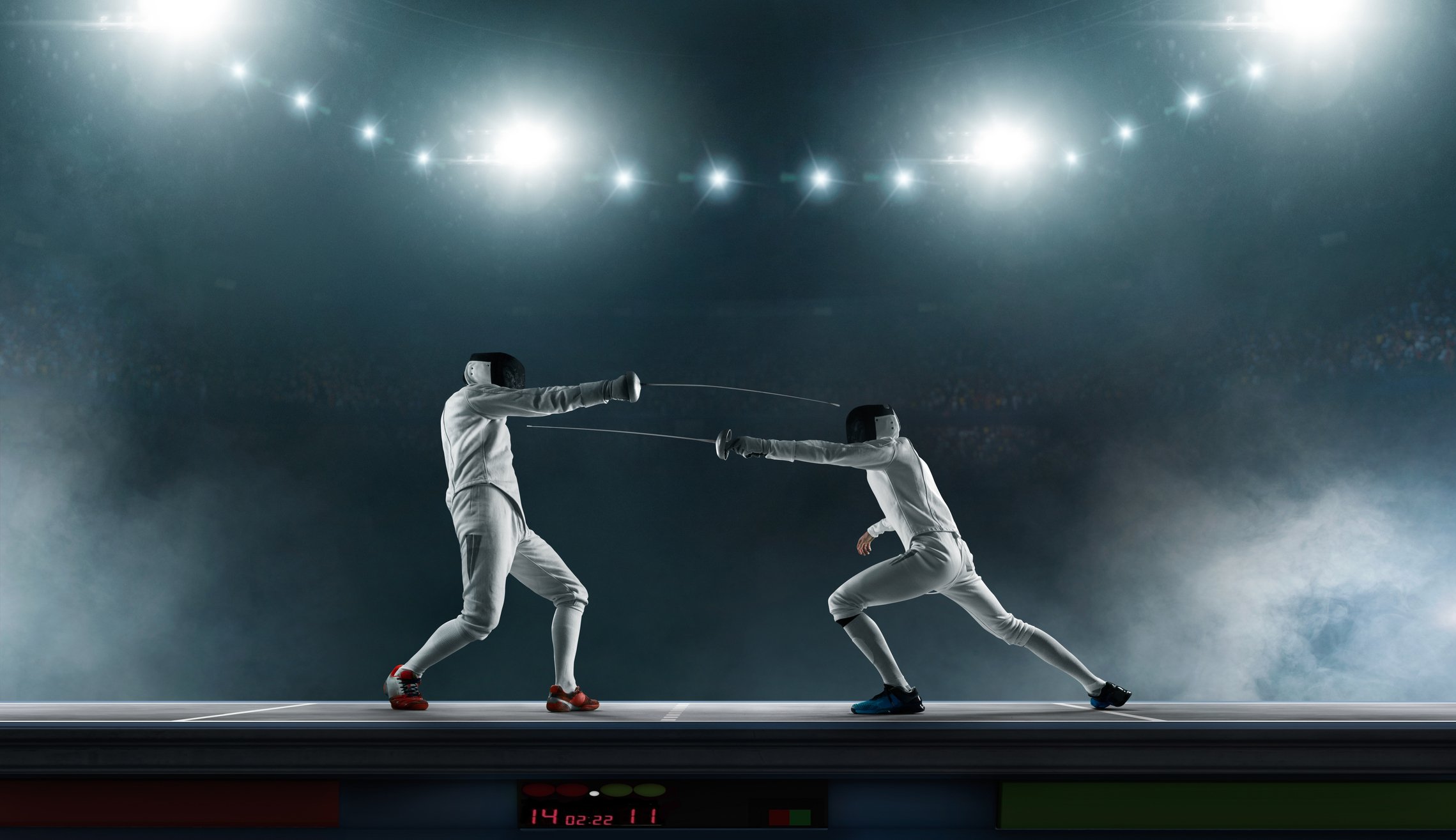 Two fencers spar in a stadium