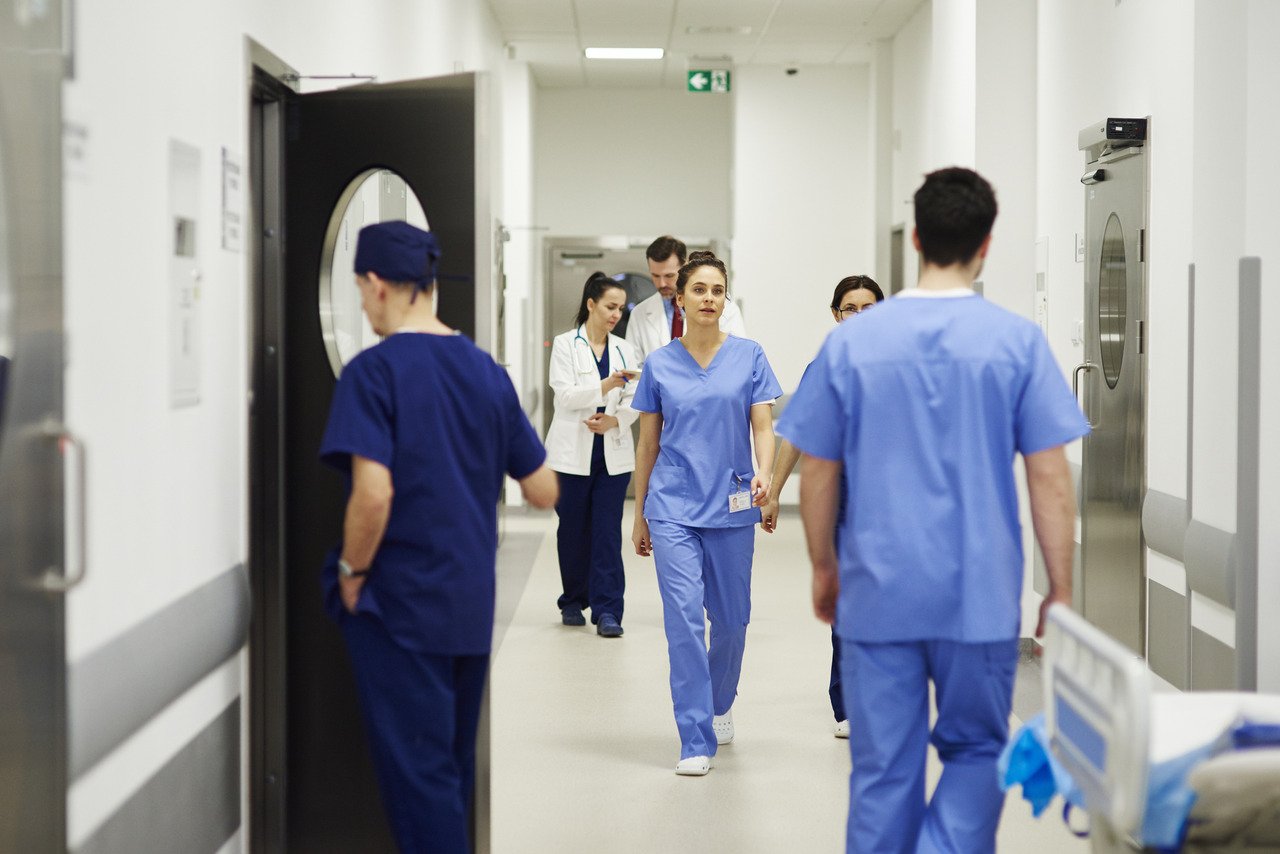 nurses medical assistants walking down hospital hallway