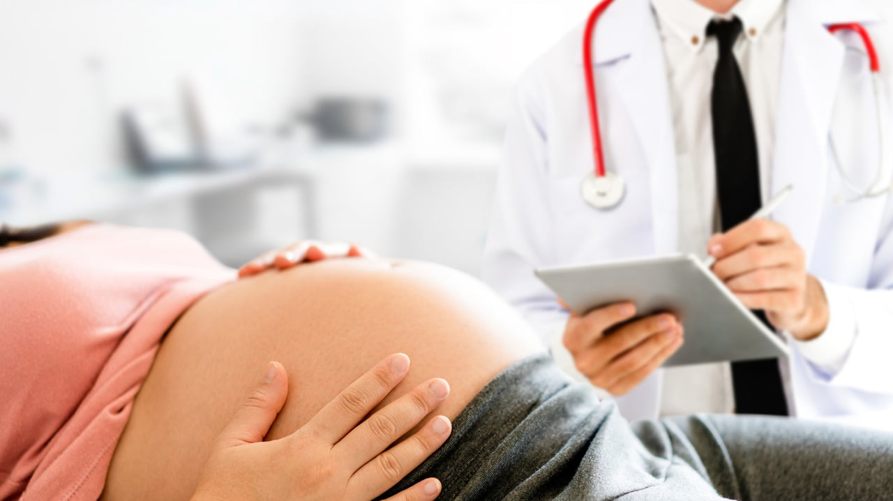 pregnant woman and gynecologist during exam at hospital
