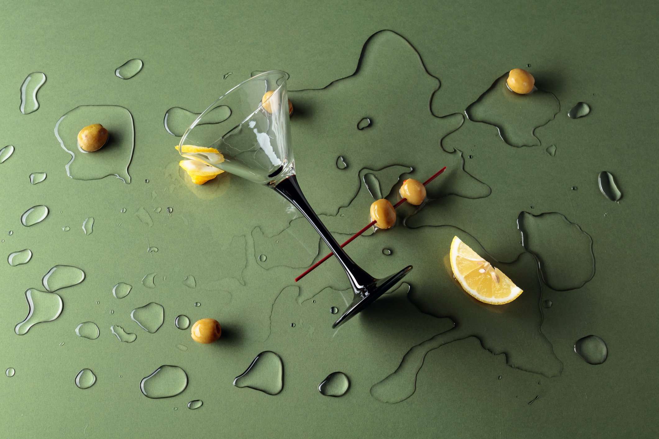 Spilled martini on green background