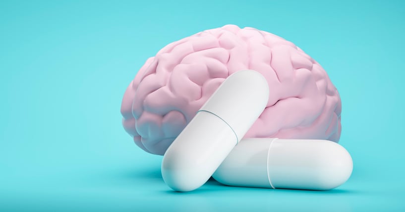 A concept image to illustrate mental health medications Models of a pink brain and two white pills which are about the size
