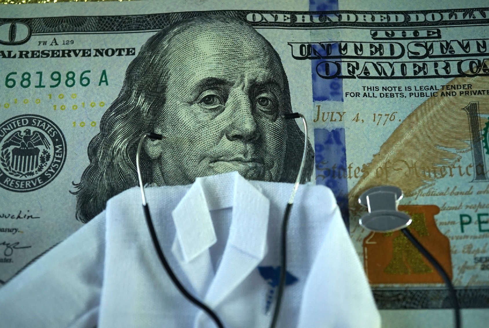 Doctor jacket and stethoscope placed in front of money
