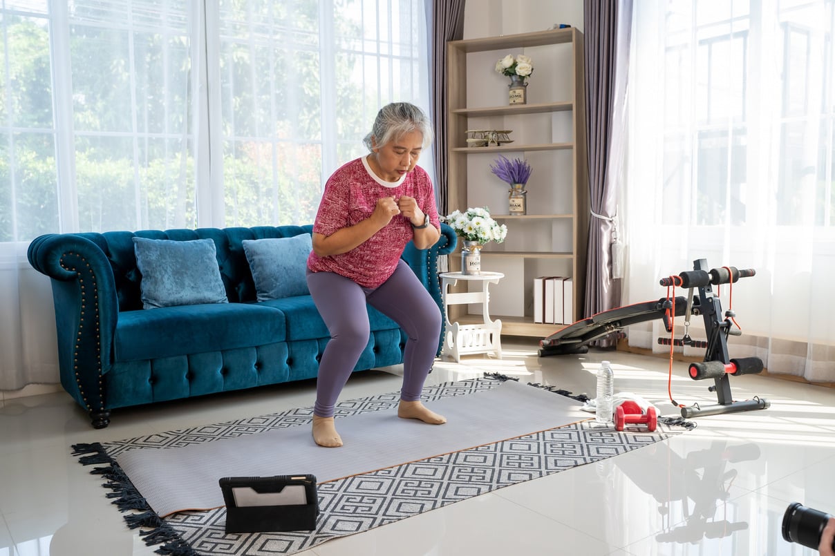 senior woman completes physical therapy exercises at home