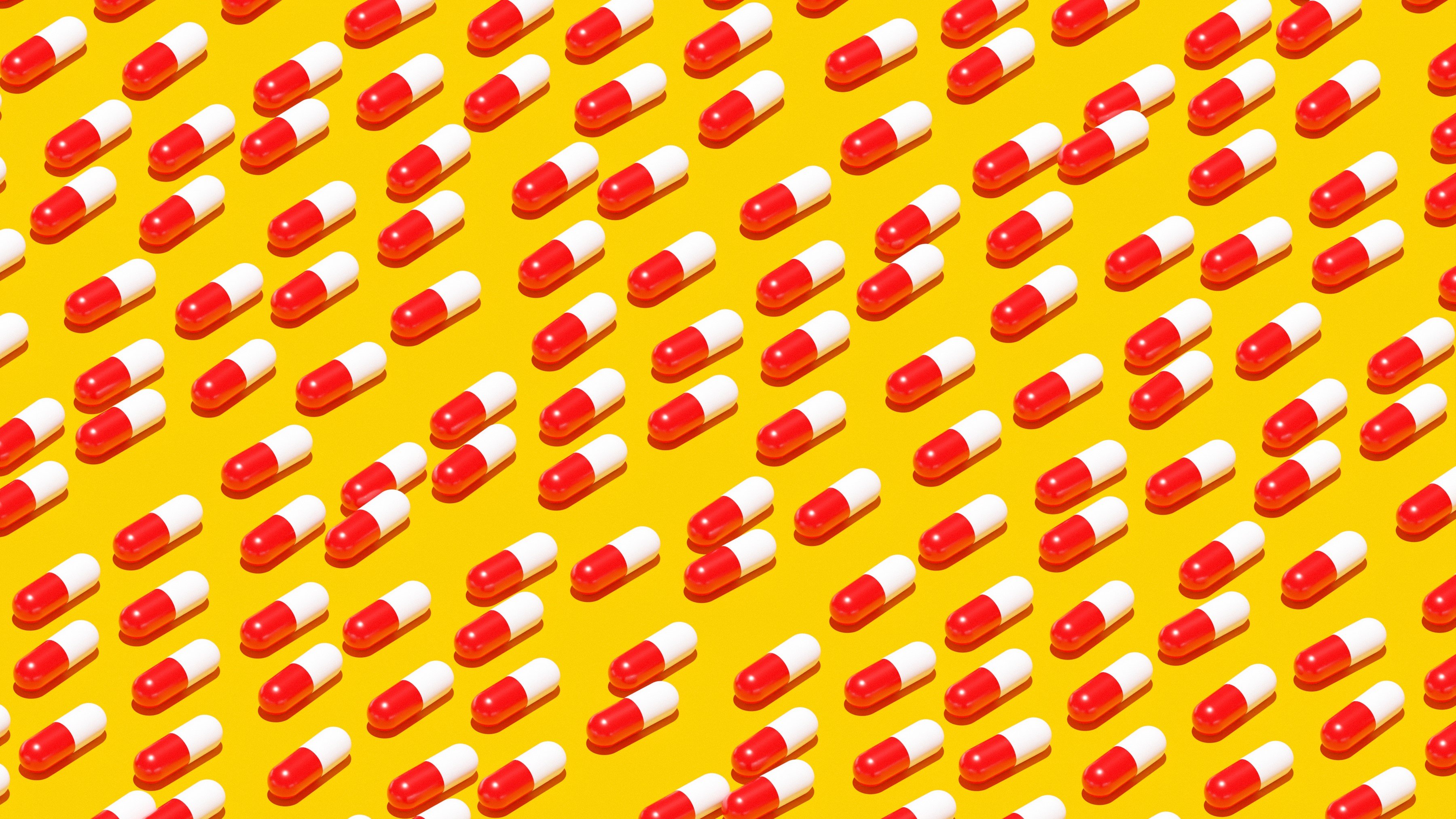 Graphic images of red and white pill capsules lined up diagonally in front of a yellow background