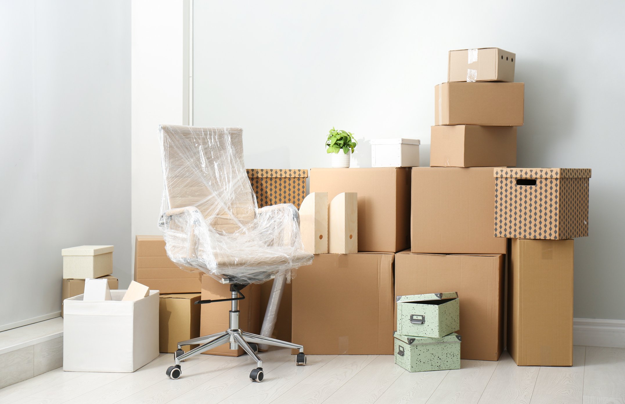 photo of packed boxes and and an office chair wrapped in bubble wrap