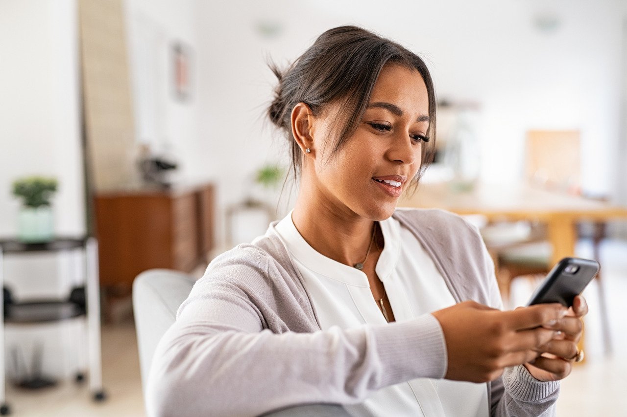 woman sitting at home on smartphone