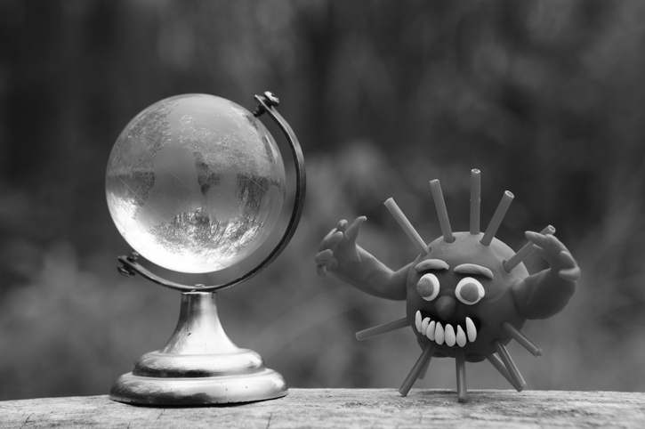 A virus figurine and a glass globe close-up in black and white