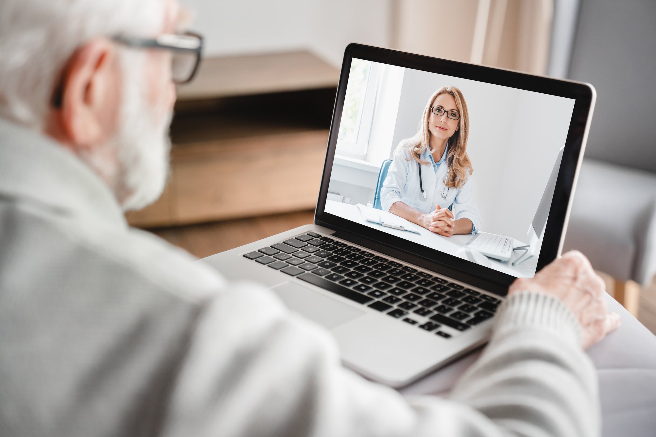 senior man speaking with doctor on video telehealth call