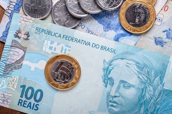 Brazilian reais bills and coins sit on a table