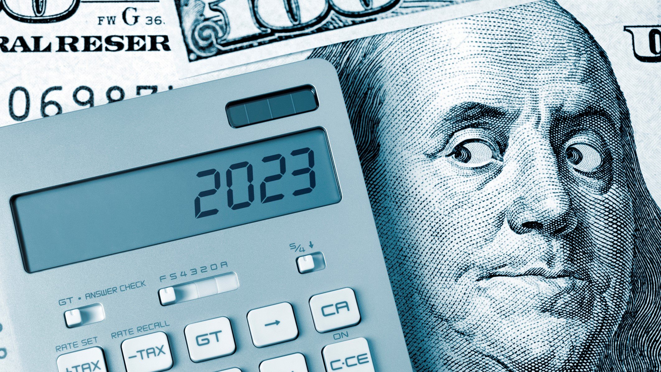 A graphic showing Benjamin Franklin on a 100 bill side-eyeing a calculator with 2023 on it