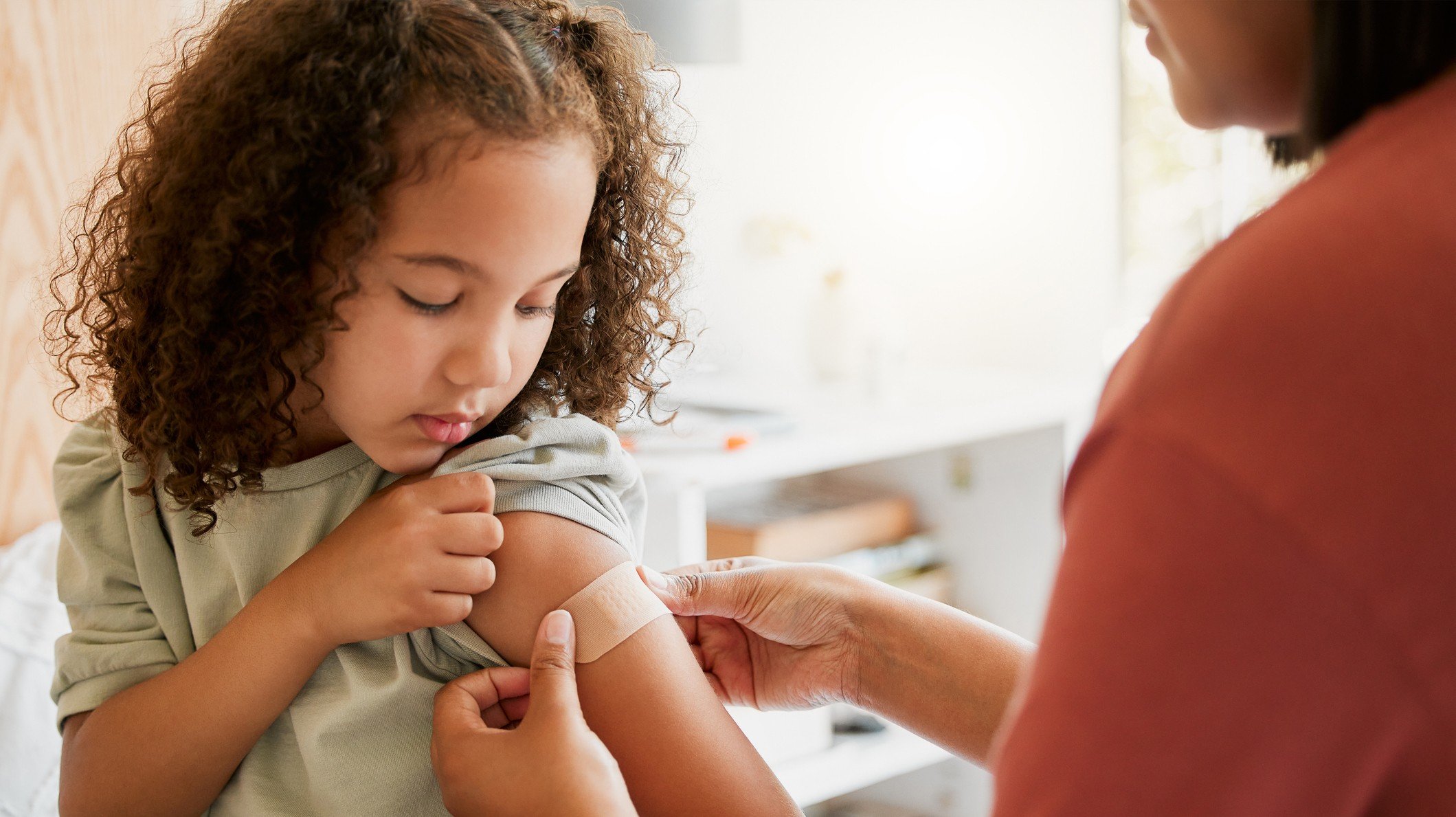 young girl getting band-aid for vaccine