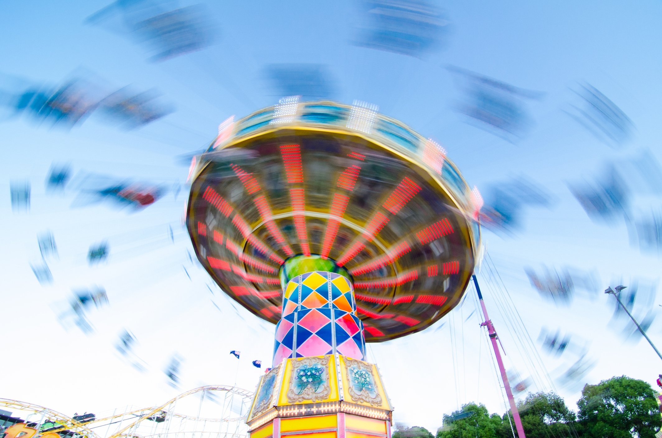 Photo of a carnival ride that swings people in elevated chairs caught in motion