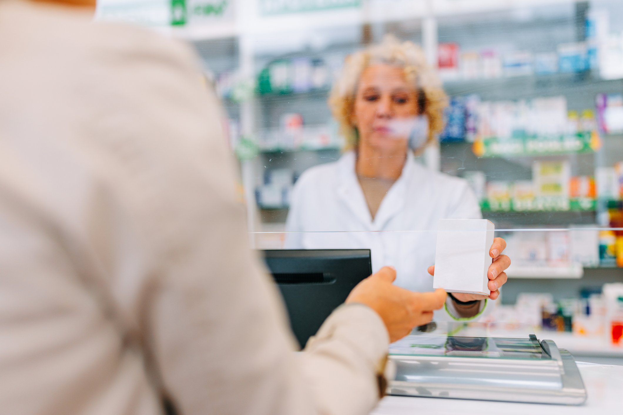 patient picking up medication at pharmacy counter 