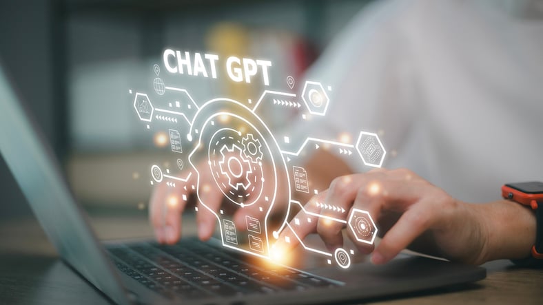 A person using a computer with a graphic that reads Chat GPT